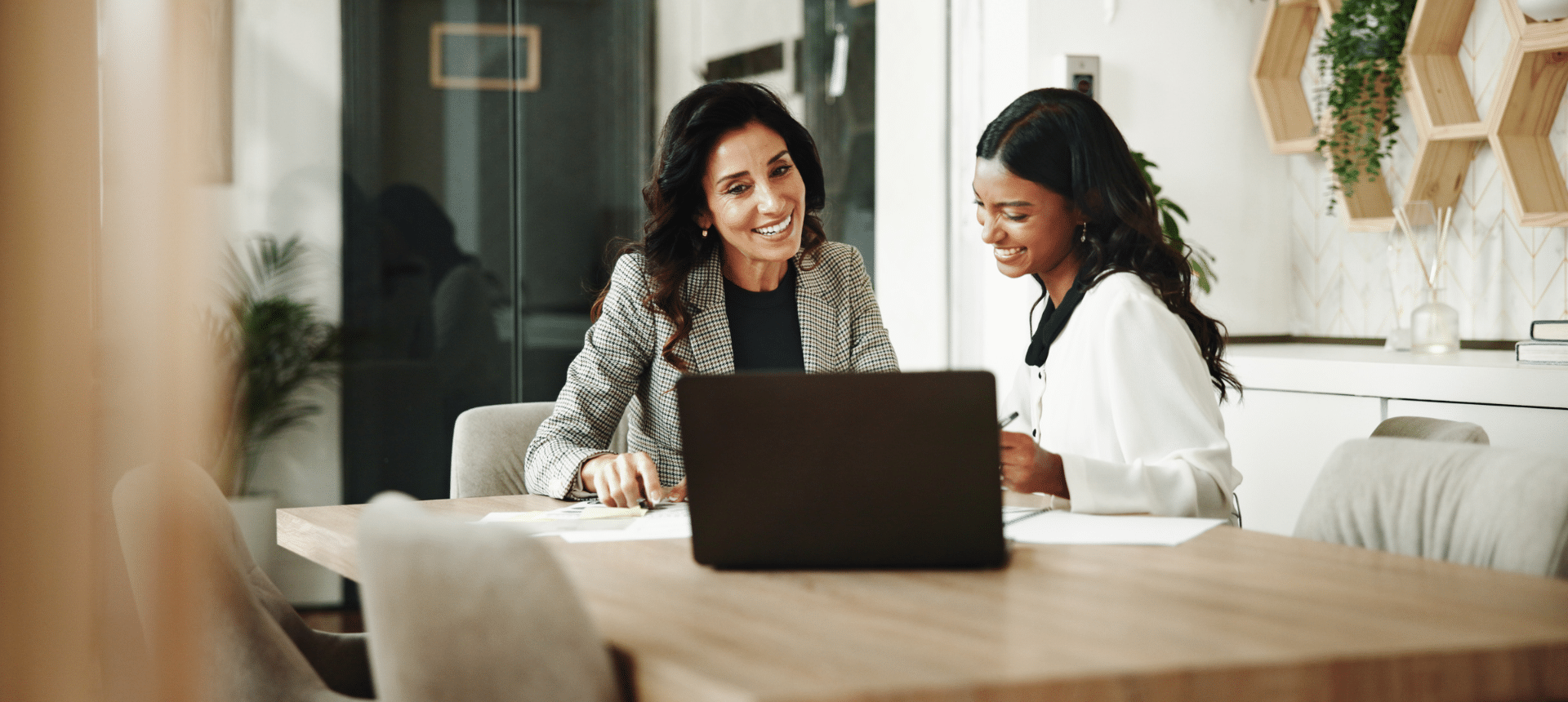 An accountant, left, in a modern office sharing details of accountants with a client, centre.